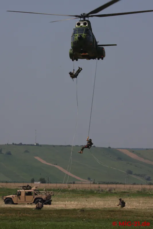 Reinforcements rappel down from the helicopters.