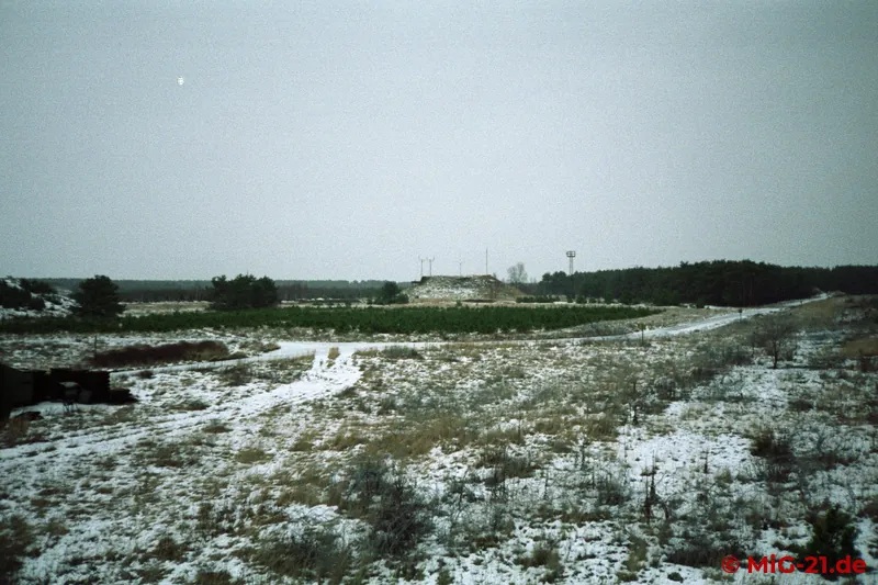 View across the snow-covered airfield to the hardened control tower.